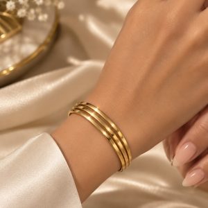 Bracelet jonc triple doré porté au poignet