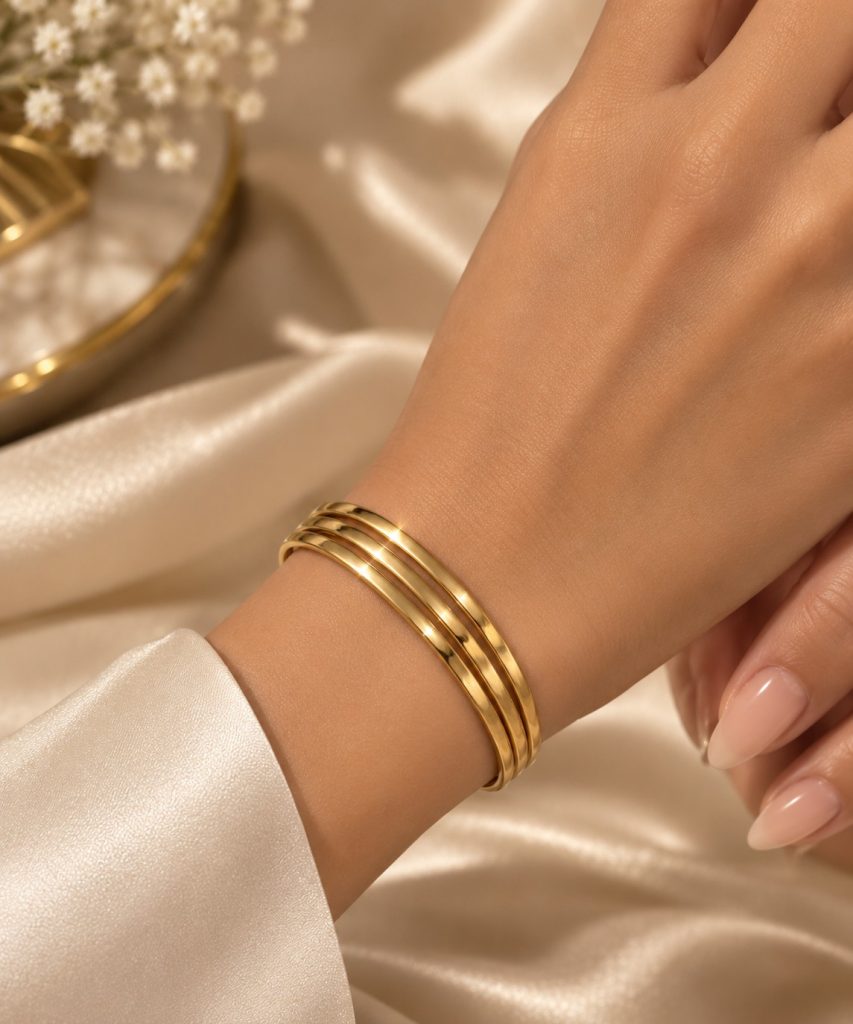 Bracelet jonc triple doré porté au poignet